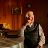 Small image of man at dinner table with empty plate