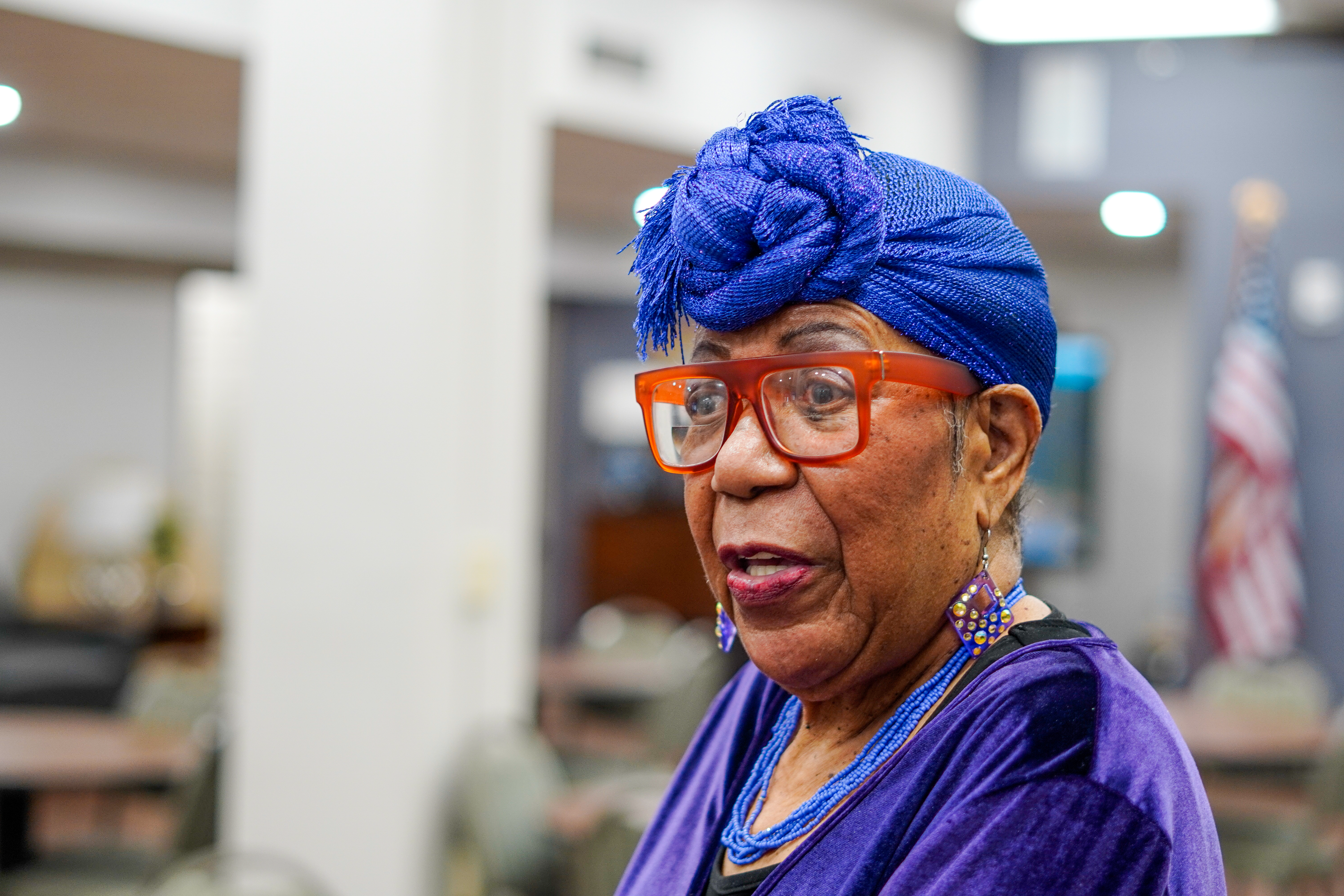 Woman with blue headscarf and red glasses