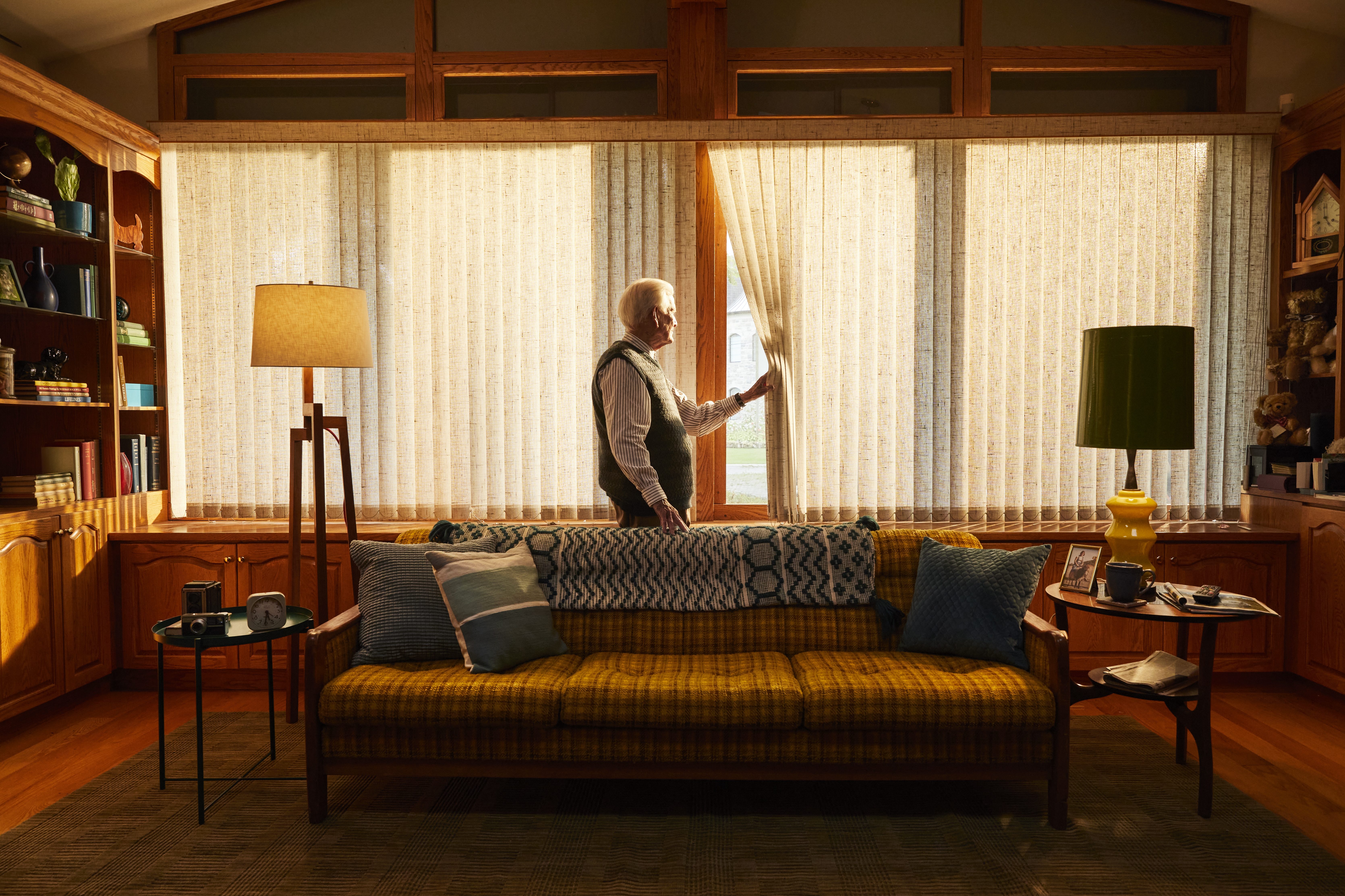 Man waiting looking out window in living room